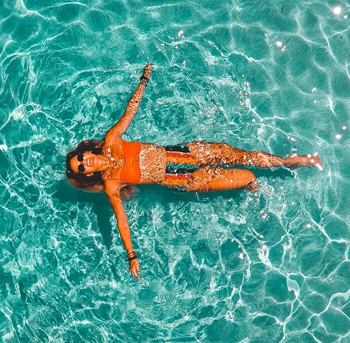 Image of women floating in the ocean with sweat and water resistant transdermal patch